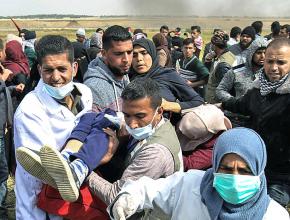 Medics rush to treat a Palestinian woman wounded by Israeli snipers during demonstrations in Gaza